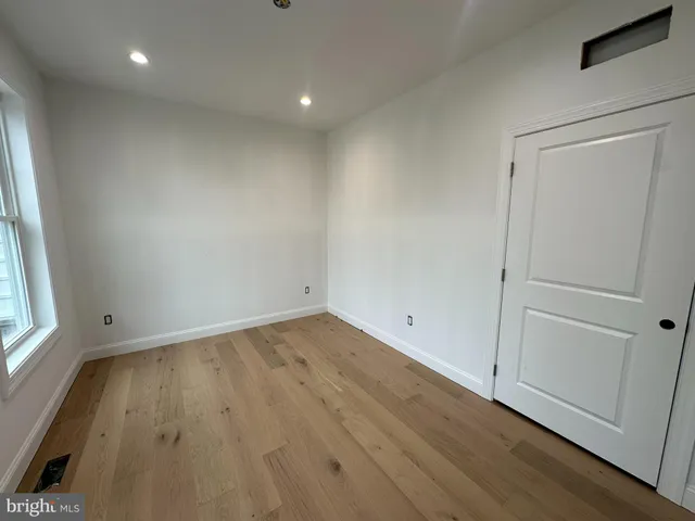 an empty room with wooden floor and window