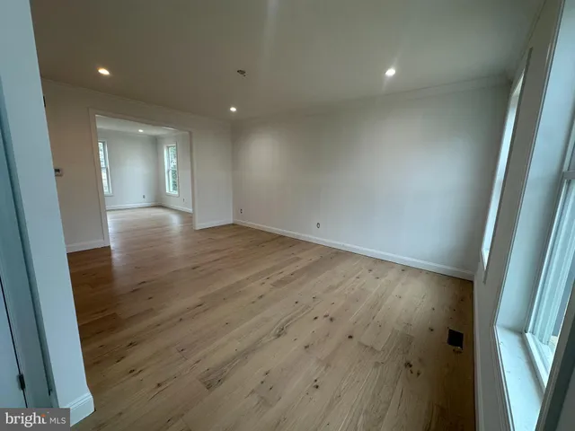 an empty room with wooden floor and entrance