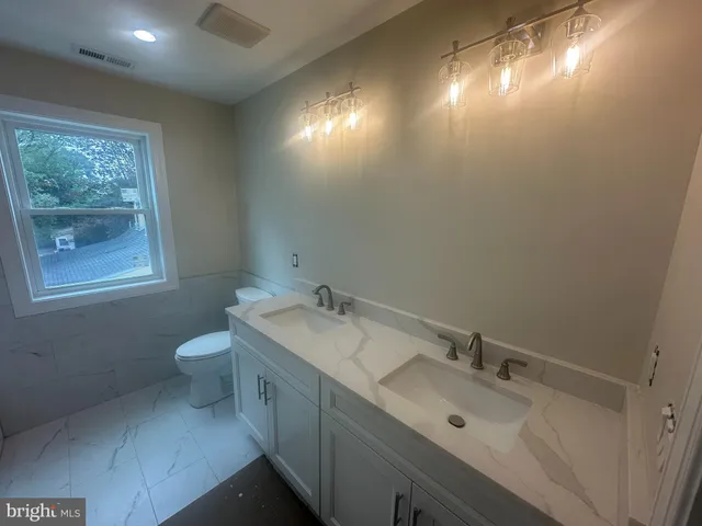 a bathroom with a sink and mirror with toilet