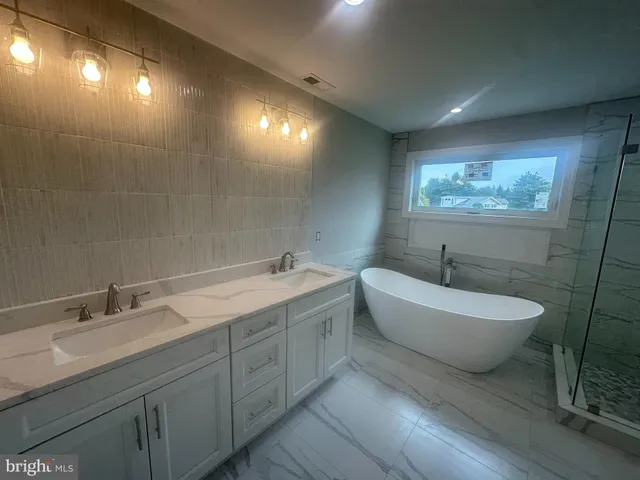 a spacious bathroom with a double vanity sink toilet and a mirror