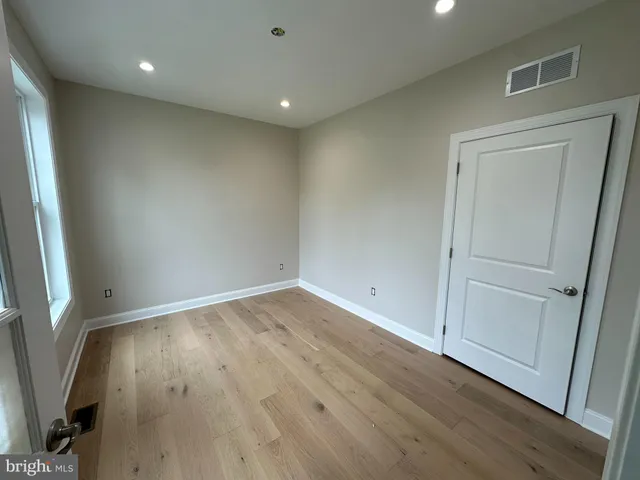 an empty room with wooden floor and entrance