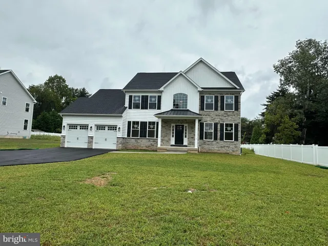 a front view of a house with a yard and trees