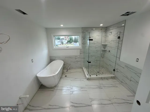 a bathroom with a granite countertop toilet a sink and shower