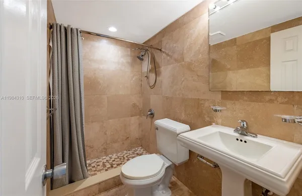 a bathroom with a sink toilet and shower