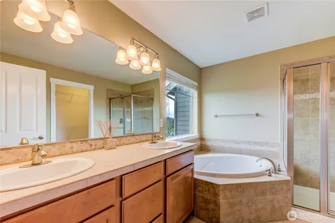 a bathroom with a granite countertop sink and a large mirror
