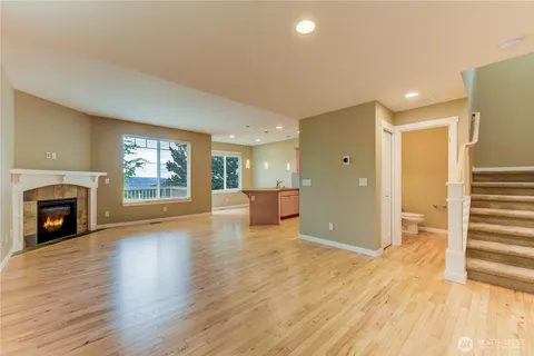 a view of a livingroom with wooden floor and a fireplace