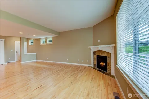 a view of an empty room with a fireplace and a window