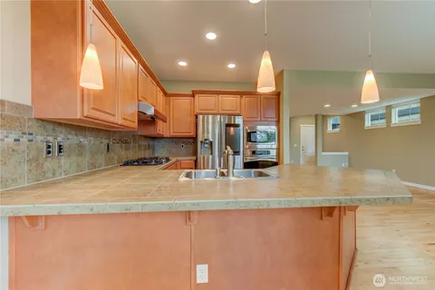 a view of kitchen with stainless steel appliances granite countertop sink and cabinets