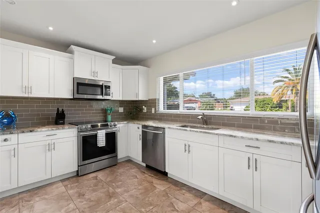 a kitchen with sink a microwave and cabinets