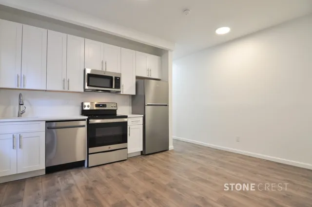 a kitchen with a refrigerator stove and white cabinets