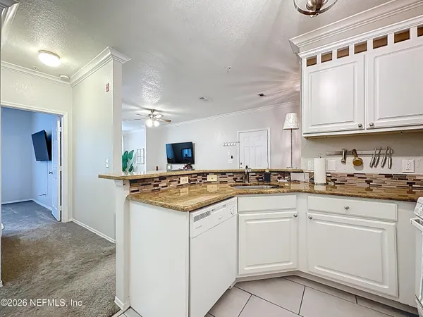 a kitchen with granite countertop a sink and cabinets