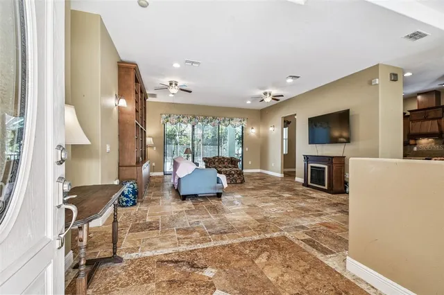 a living room with furniture a flat screen tv and a large window