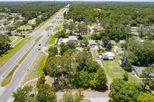 an aerial view of residential houses with outdoor space and trees