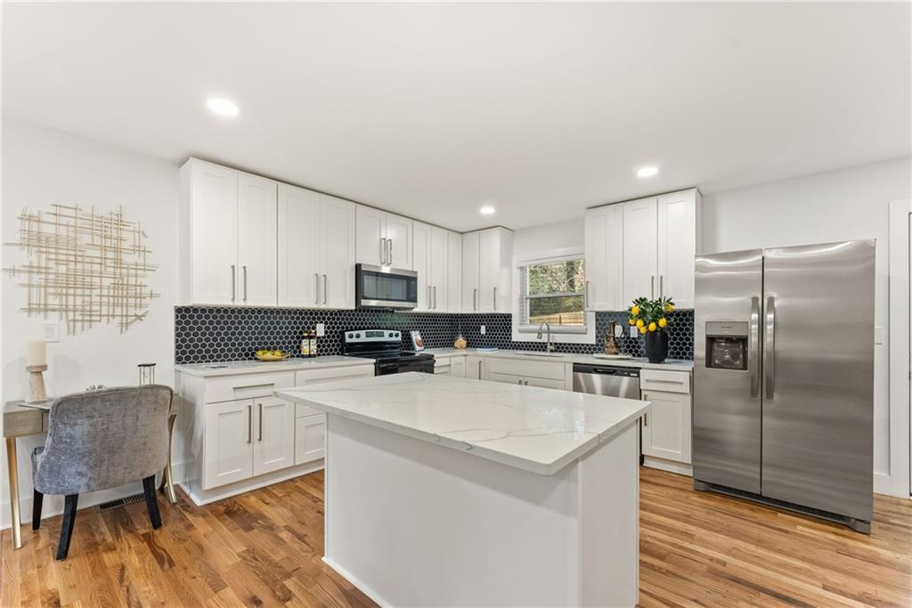 3372 Jackson Drive Decatur, GA 30032 - Photo 8 of 26 a kitchen with a refrigerator a stove a sink a dining table and chairs