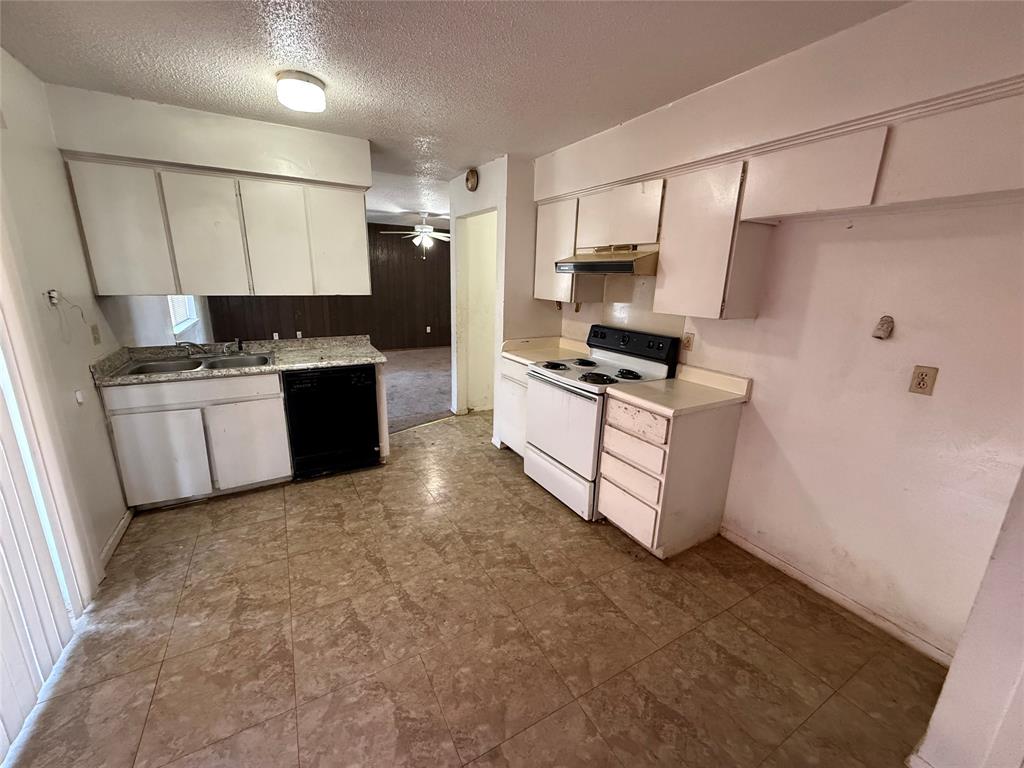 1334 Rutherford Drive Mesquite, TX 75149 - Photo 9 of 22 a kitchen with granite countertop a sink a stove top oven a refrigerator and cabinets