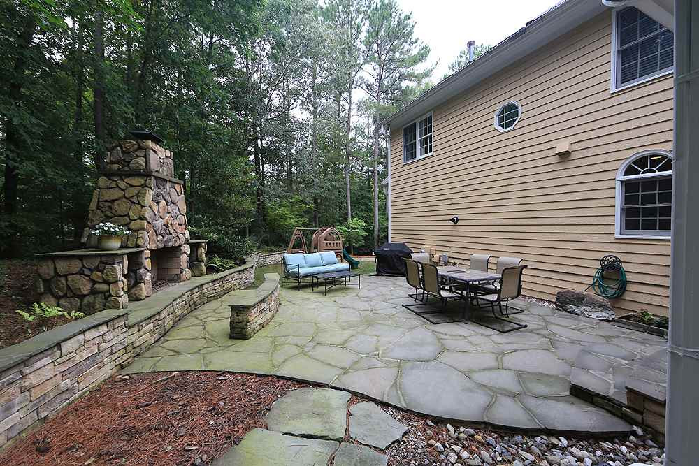 5921 Wild Orchid Trail Raleigh, NC 27613 - Photo 27 of 30 Large flagstone patio with wooded views and your own private outdoor fireplace. Patio