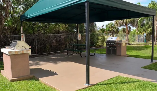 a view of a patio with table and chairs potted plants with a barbeque grill