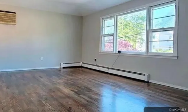 a view of a room with wooden floor and a window