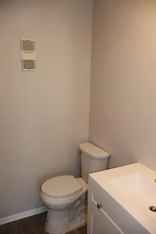 a white toilet sitting next to a white wall