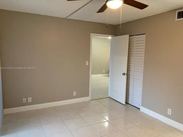 an empty room with a window and a fan