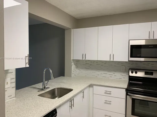 a kitchen with granite countertop a sink and cabinets