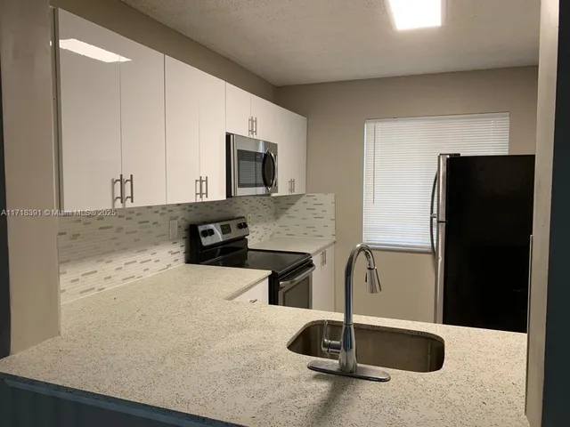 a kitchen with a refrigerator and a sink