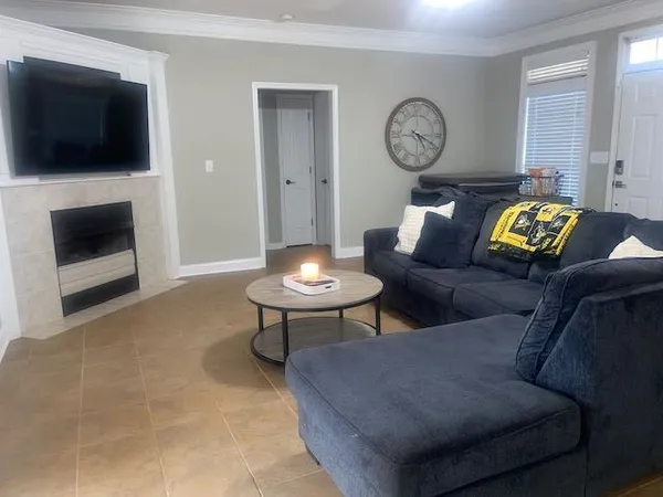 a living room with furniture a flat screen tv and a fireplace