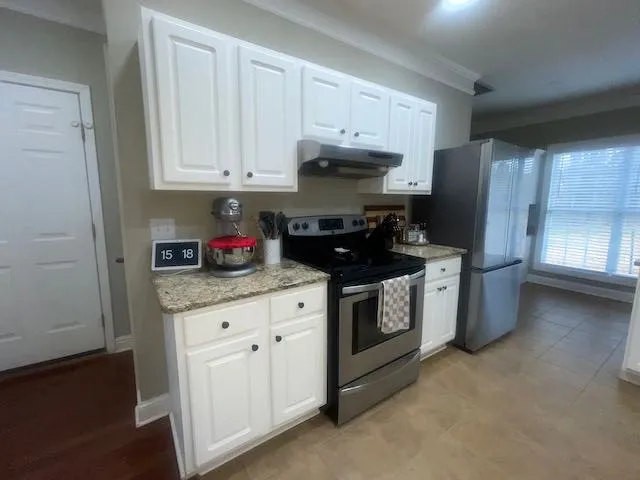 a kitchen with stainless steel appliances granite countertop a refrigerator sink and cabinets