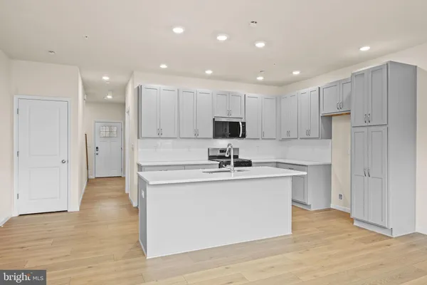 a kitchen with kitchen island a sink stainless steel appliances and cabinets