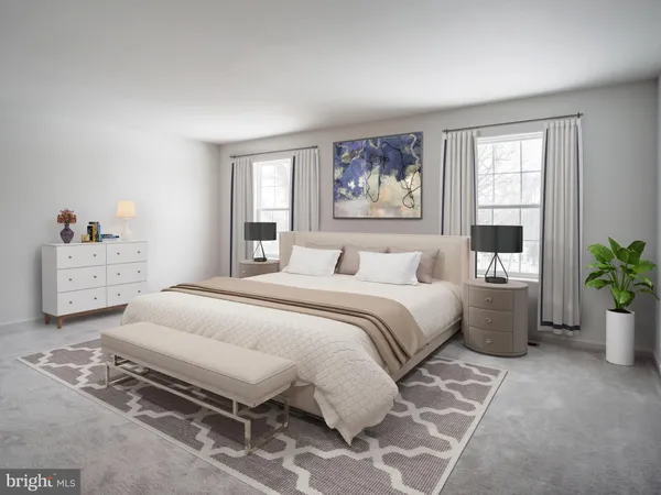a bedroom with a large bed a potted plant and a window