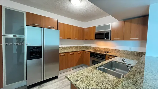 a kitchen with stainless steel appliances granite countertop a refrigerator and a stove top oven