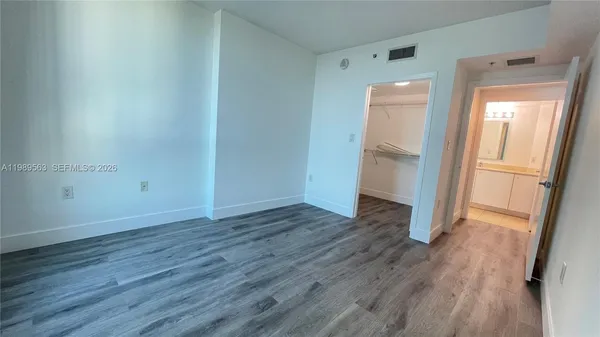 a view of empty room with wooden floor and window