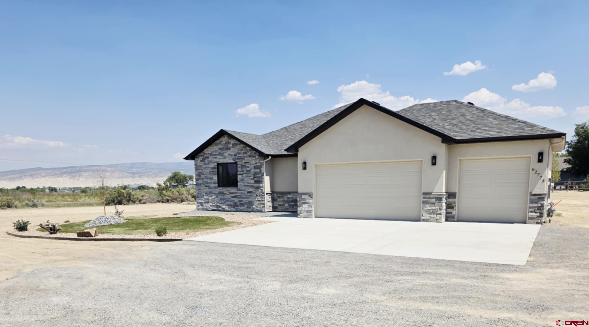 62774 Jacob Road Montrose, CO 81401 - Photo 2 of 35 a view of a house with a yard and large tree in front of it