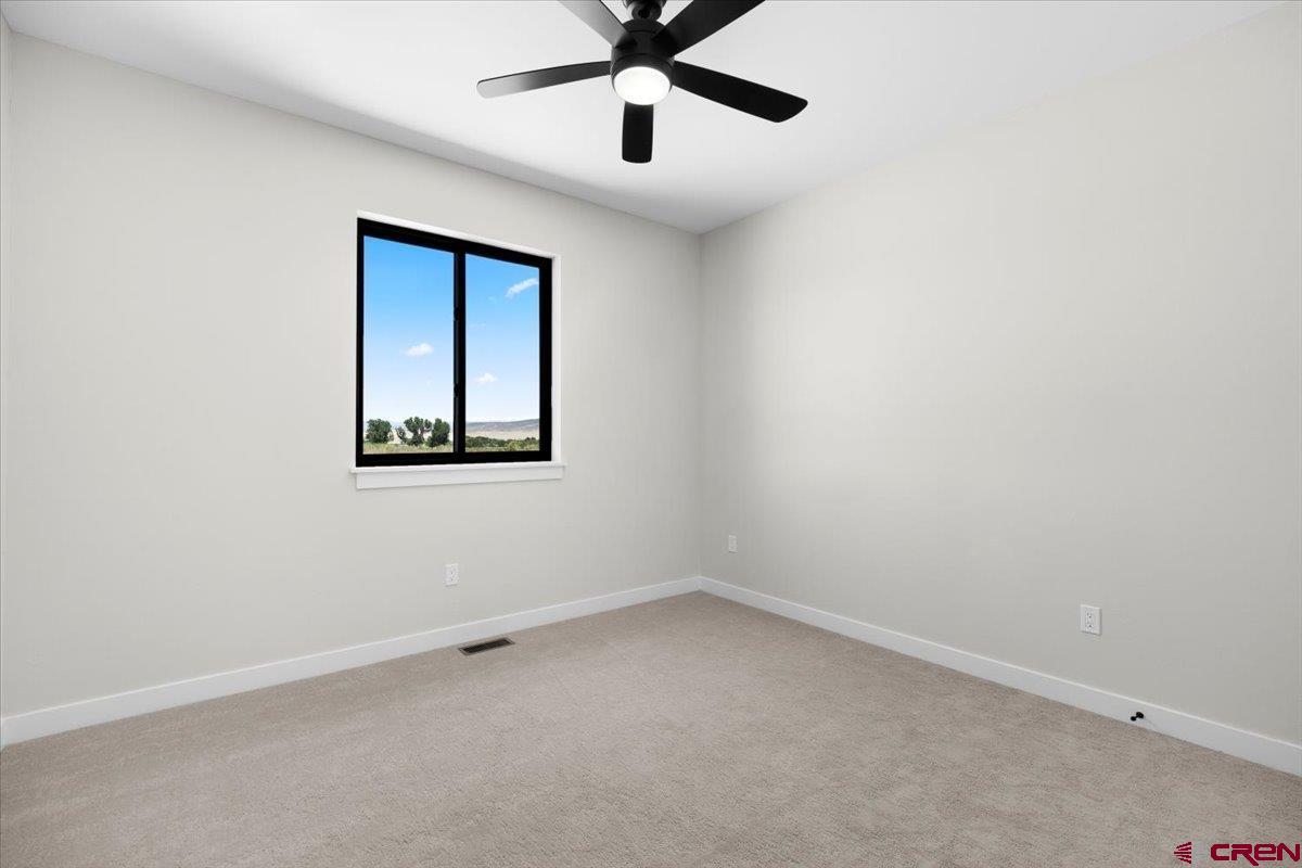 62774 Jacob Road Montrose, CO 81401 - Photo 26 of 35 an empty room with a ceiling fan and a window