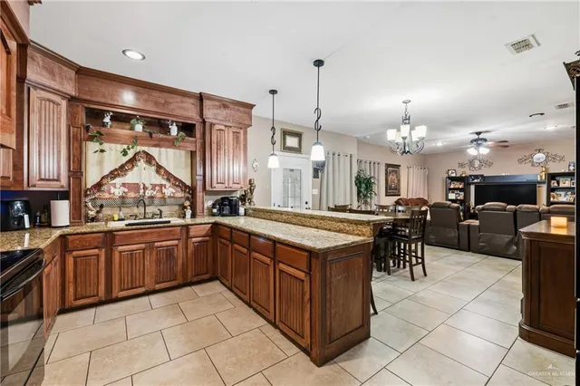 a kitchen with stainless steel appliances granite countertop a stove a sink and a refrigerator