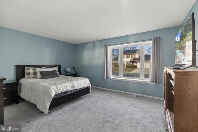 a spacious bedroom with a bed next to a window