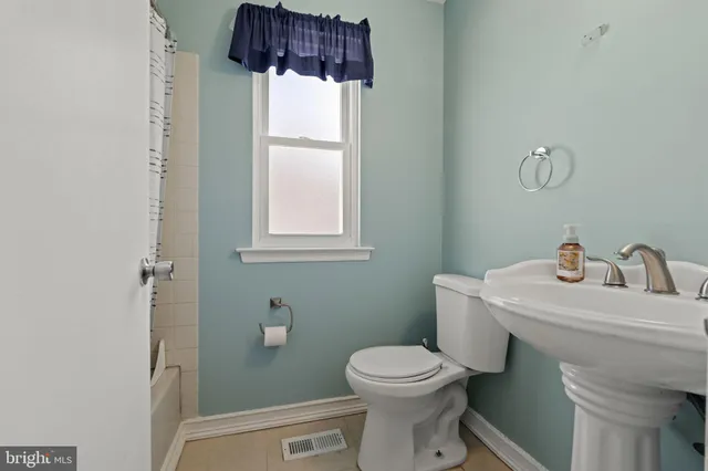 a bathroom with a sink a toilet and window