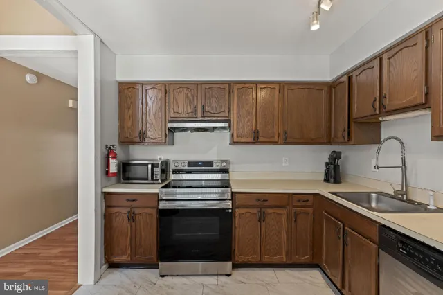 a kitchen with stainless steel appliances granite countertop a sink stove and cabinets