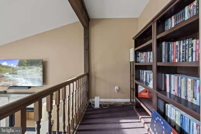 a view of room with wooden floor and book shelf