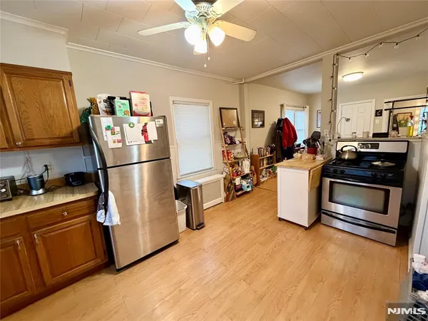 a kitchen with stainless steel appliances granite countertop a refrigerator a stove a sink dishwasher and a refrigerator with wooden floor