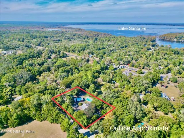 a view of a swimming pool with lawn chairs under an umbrella