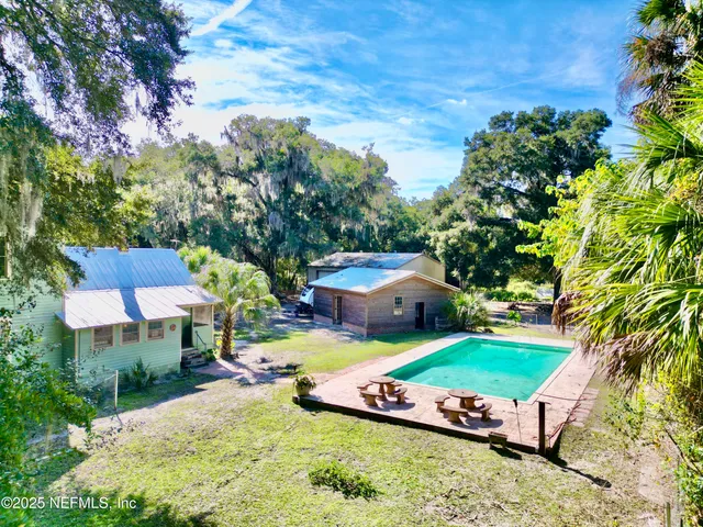 a view of a house with a yard and wooden fence
