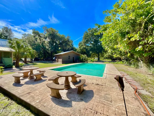 a view of an house with backyard space and swimming pool