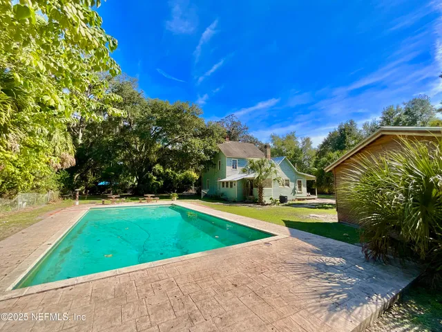 a view of a yard with plants and trees