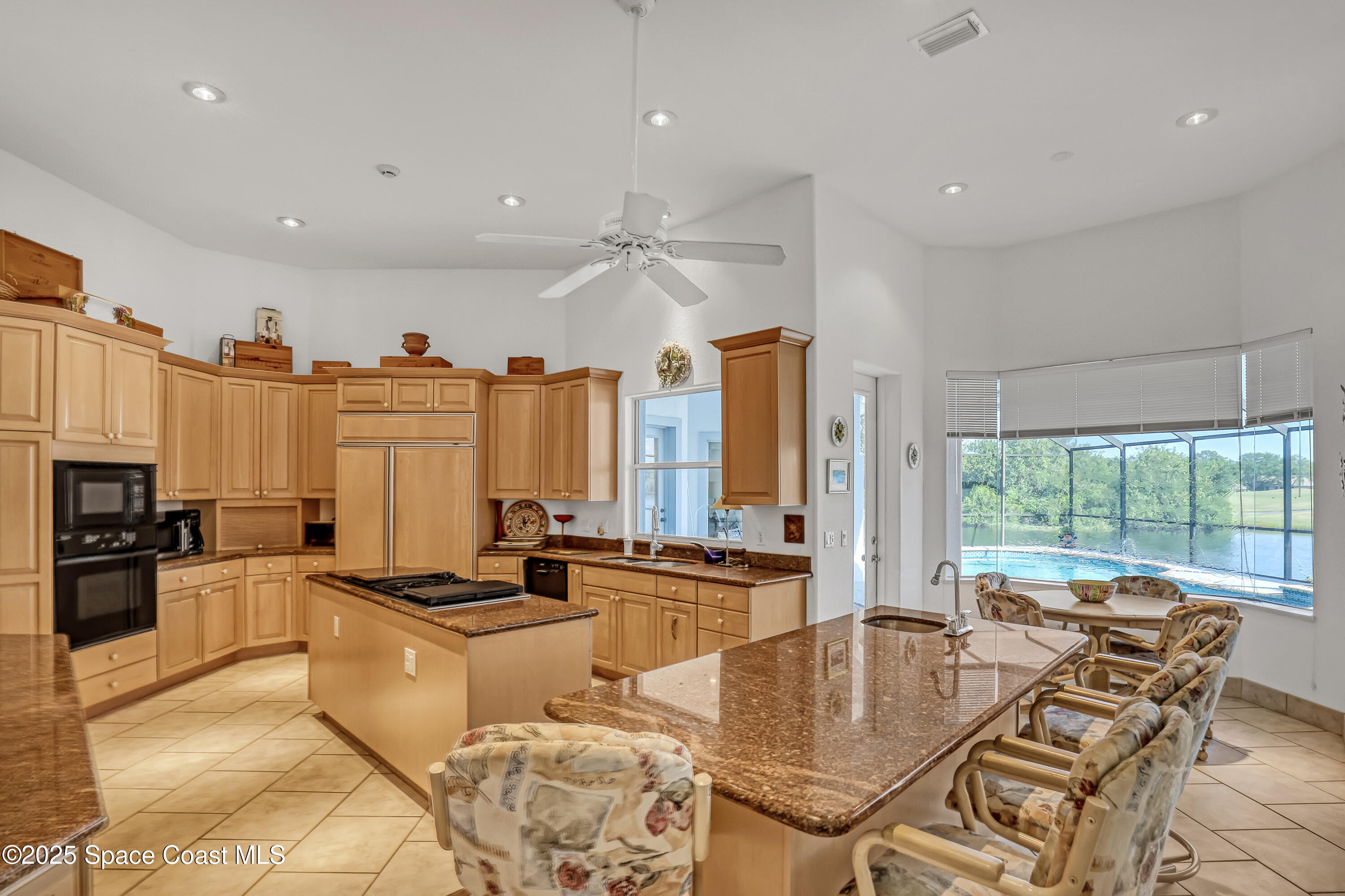 813 Hogan Way Melbourne, FL 32940 - Photo 11 of 50 a kitchen with stainless steel appliances granite countertop a stove a refrigerator a sink and white cabinets with wooden floor