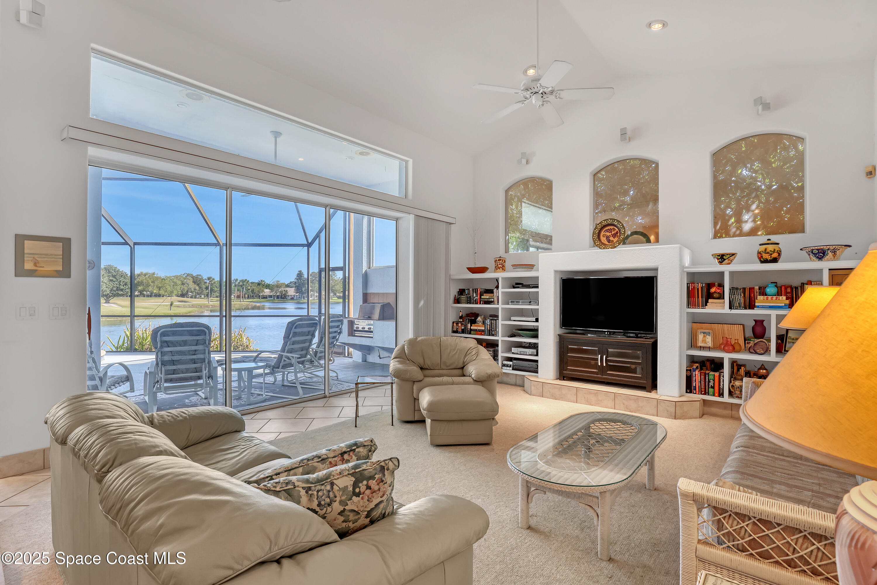 813 Hogan Way Melbourne, FL 32940 - Photo 18 of 50 a living room with furniture a fireplace and a floor to ceiling window