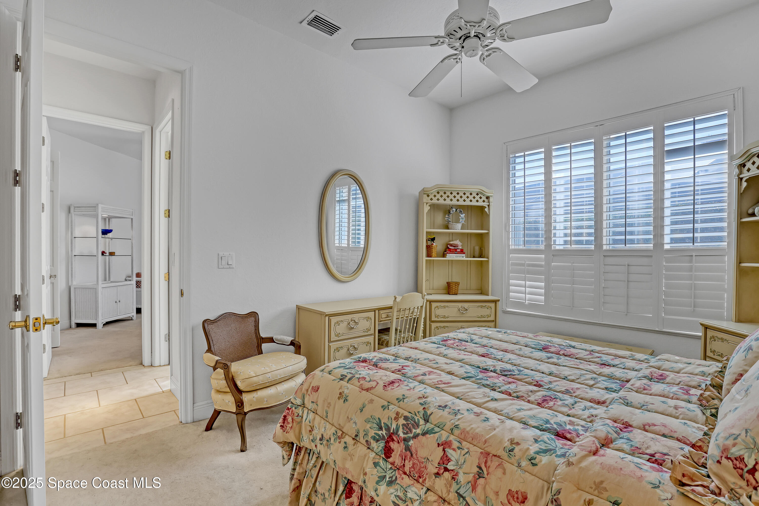 813 Hogan Way Melbourne, FL 32940 - Photo 25 of 50 a bedroom with a bed a mirror and a window