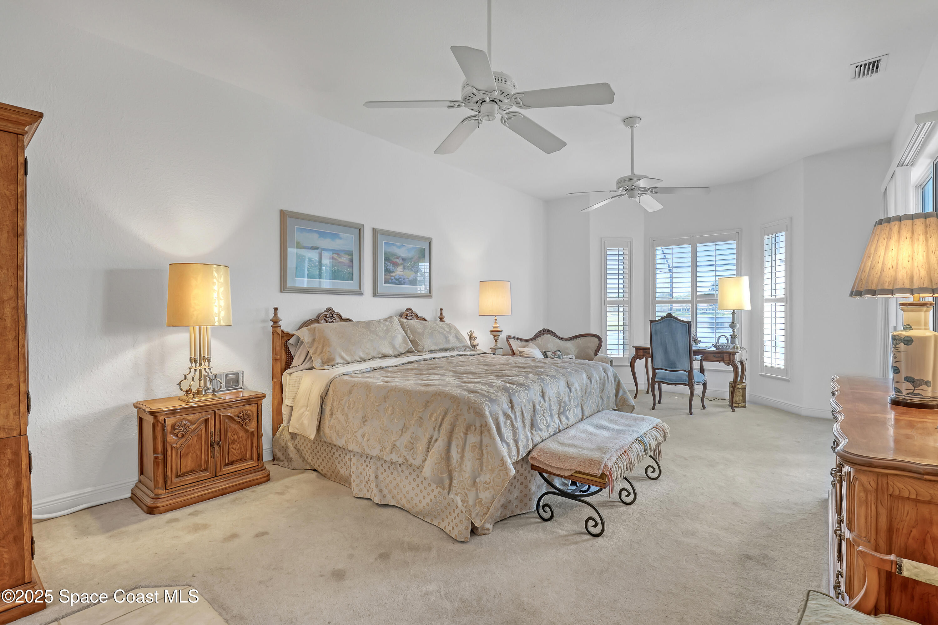 813 Hogan Way Melbourne, FL 32940 - Photo 28 of 50 a spacious bedroom with a bed a couch and a chandelier