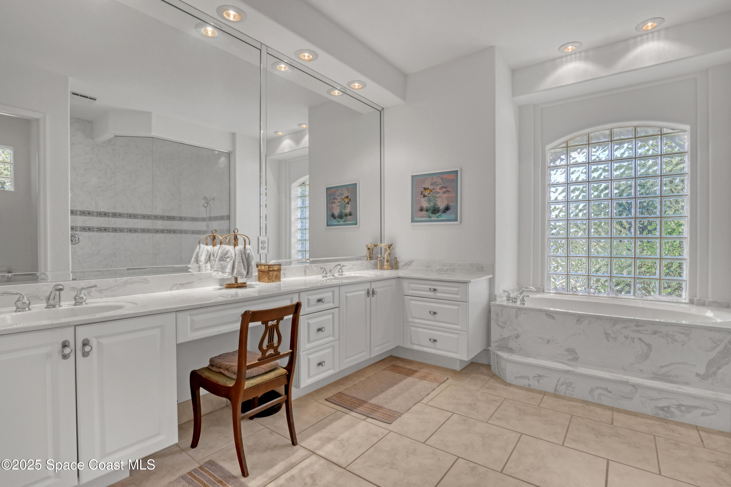 813 Hogan Way Melbourne, FL 32940 - Photo 30 of 50 a spacious bathroom with a granite countertop sink a mirror and a bathtub