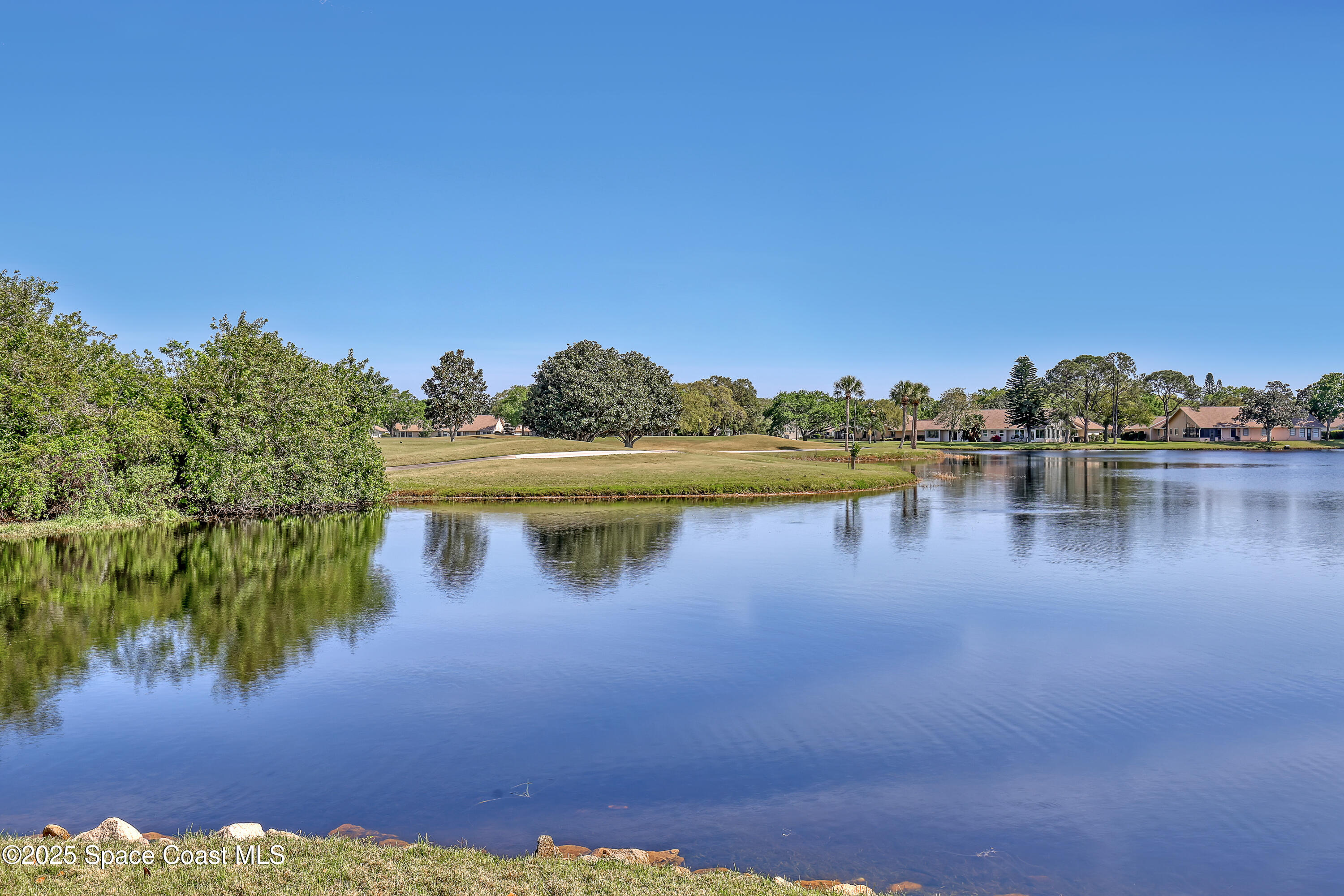 813 Hogan Way Melbourne, FL 32940 - Photo 37 of 50 a view of a lake with houses in the background